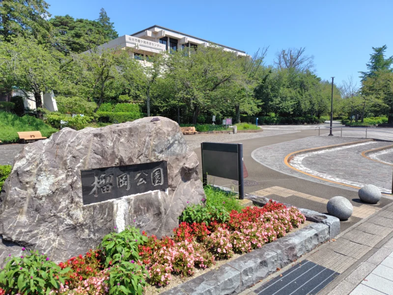 石碑と緑が見える榴岡公園の入口