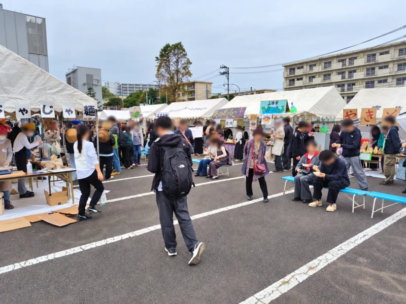 東北大学祭の屋外会場に並ぶ多数の模擬店と食事を楽しむ来場者
